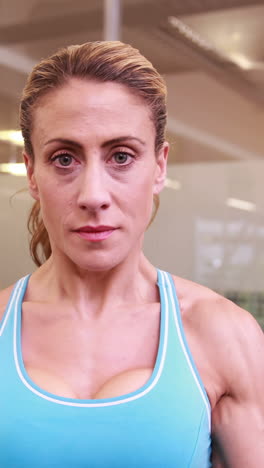 mujer súper en forma levantando pesas en crossfit