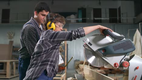 trabajadores que utilizan sierra circular en un taller de carpintería