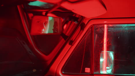 reflection on young woman in rear view mirror in car