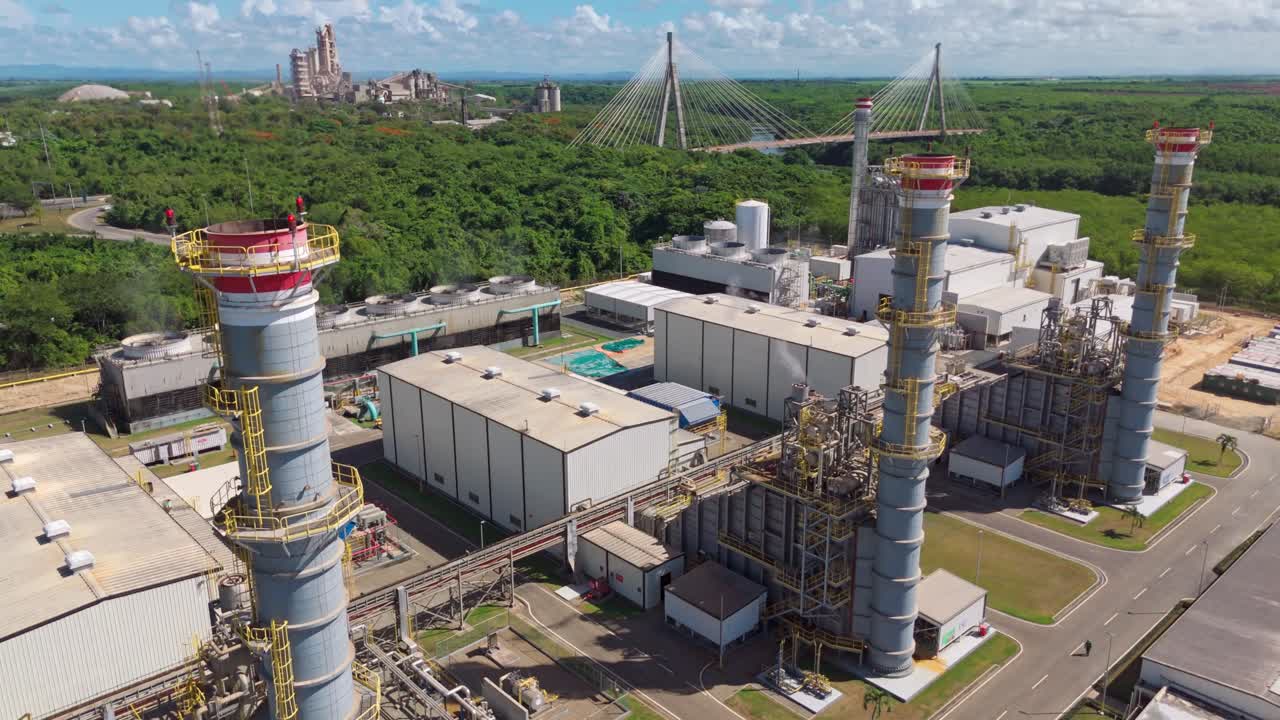 Tilt up view of the Energa 4 power generation facility, fuel storage tanks, substation, and smokestacks in Dominican Republic