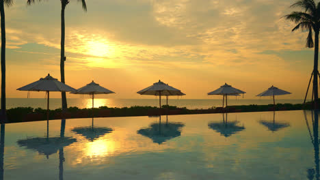 umbrella with bed pool around swimming pool with ocean sea background - holiday and vacation concept