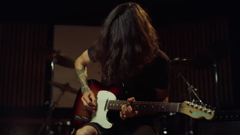 Guitarist-playing-in-concert-hall.-Male-composer-rehearsing-in-recording-studio.