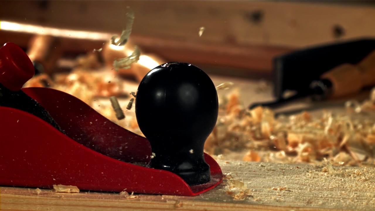 Trucioli di legno che volano da una pialla a mano al rallentatore