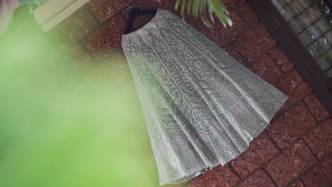 an elegant reception gown in soft green, flowing in slow motion, filmed at a dutch angle