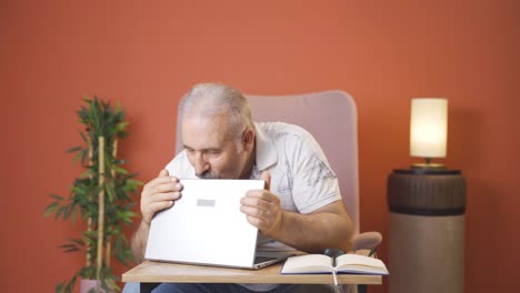 old man joyfully embracing laptop.