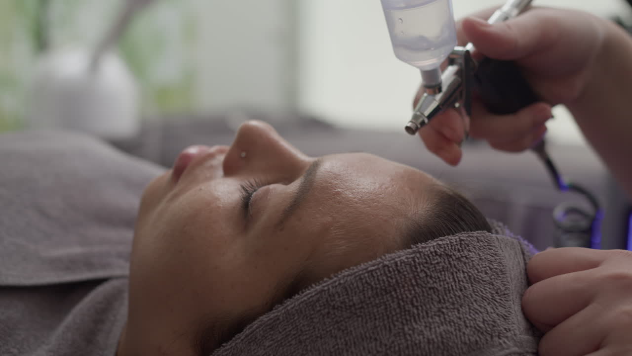 Hands of Clinician Reducing Wrinkles on Forehead of Woman with Microderm Machine