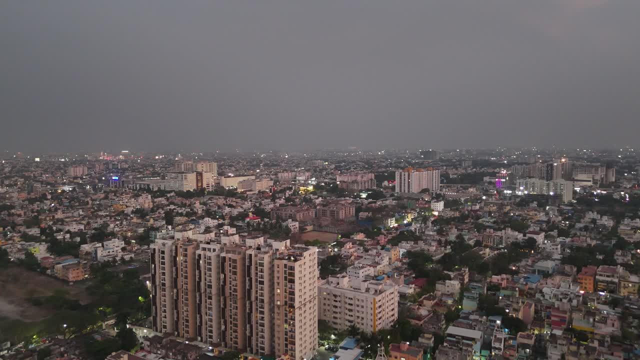 Filmato aereo con drone ad angolo elevato dello skyline di una città moderna di notte. Mostra uno splendido contrasto tra edifici e lampioni stradali. Eccellente per progetti sulla vita cittadina o sullo sviluppo urbano. India meridionale