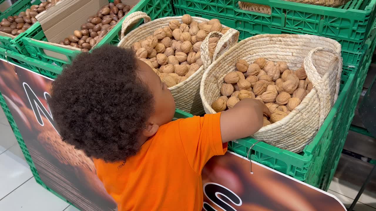 Two year old african child counting nuts in a supermarket