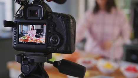 caucasian vlogger woman doing a cooking video at home