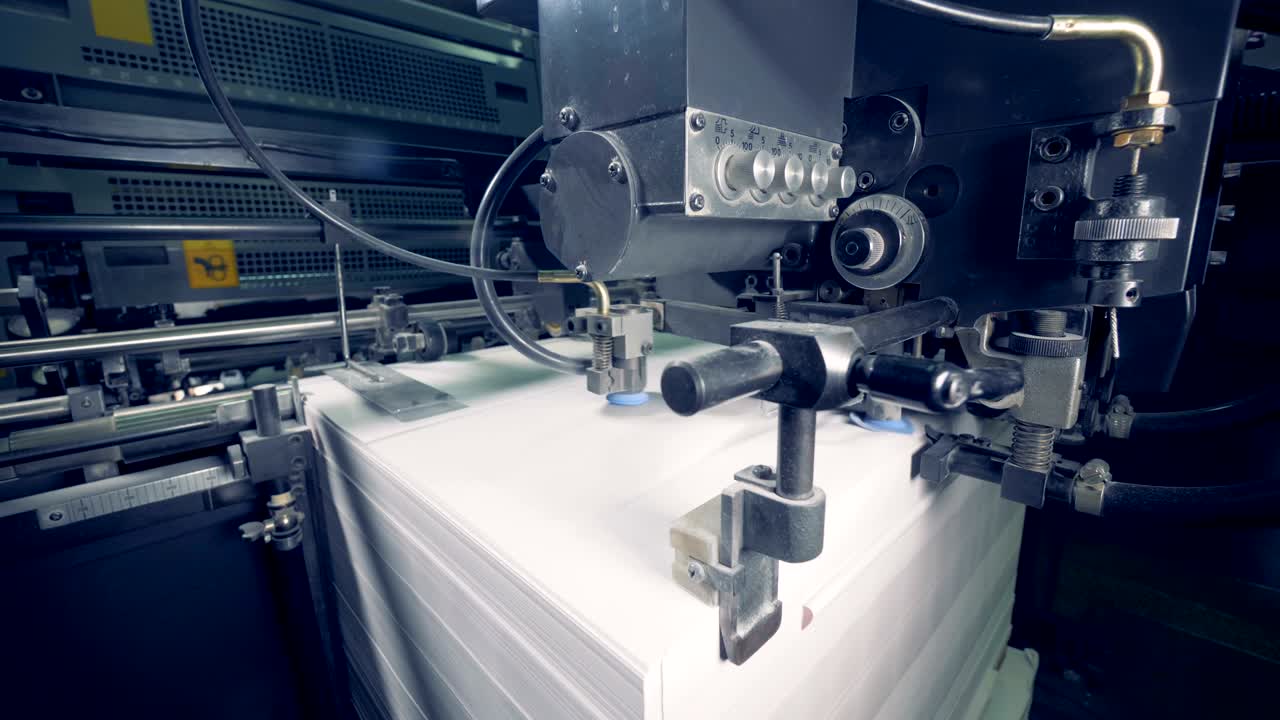 거대한 종이 종이가 자동 공장 기계에 의해 옮겨지고 있습니다.