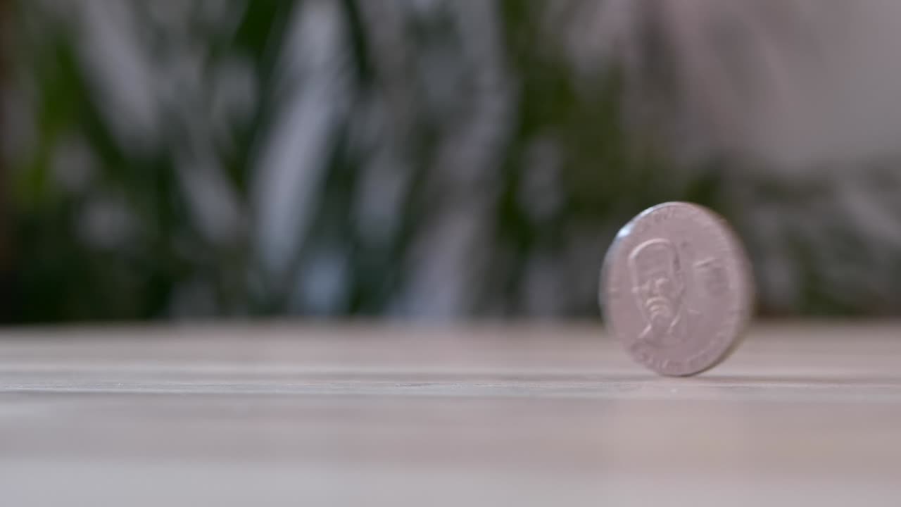 macro cierre de moneda volteando sobre la mesa, 50 centavos de dólar ecuatoriano, cámara lenta