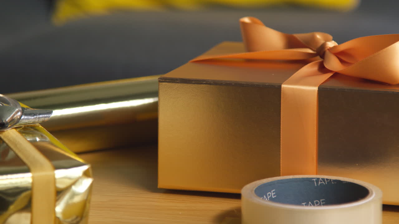 집에서 포장 종이와 접착 테이프로 테이블에 포장 된 선물의 가까운 모습