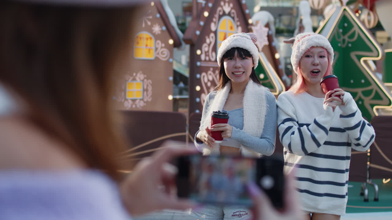 Women in winter fashion taking photos at Christmas