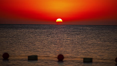 tiro de lapso de tiempo de la puesta de sol dorada detrás del mar en el horizonte por la noche, plano general
