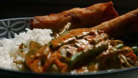 Focus-Pull-Across-Plated-Vegan-Thai-Red-Curry-with-Rice-and-Spring-Rolls