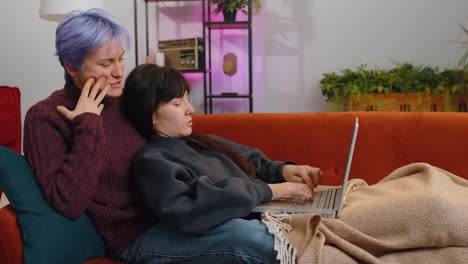 two lesbian women family couple or girls friends closing laptop pc after finishing work at home