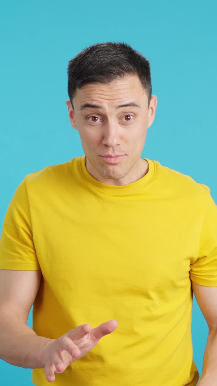 Man gesturing in front of a blue background