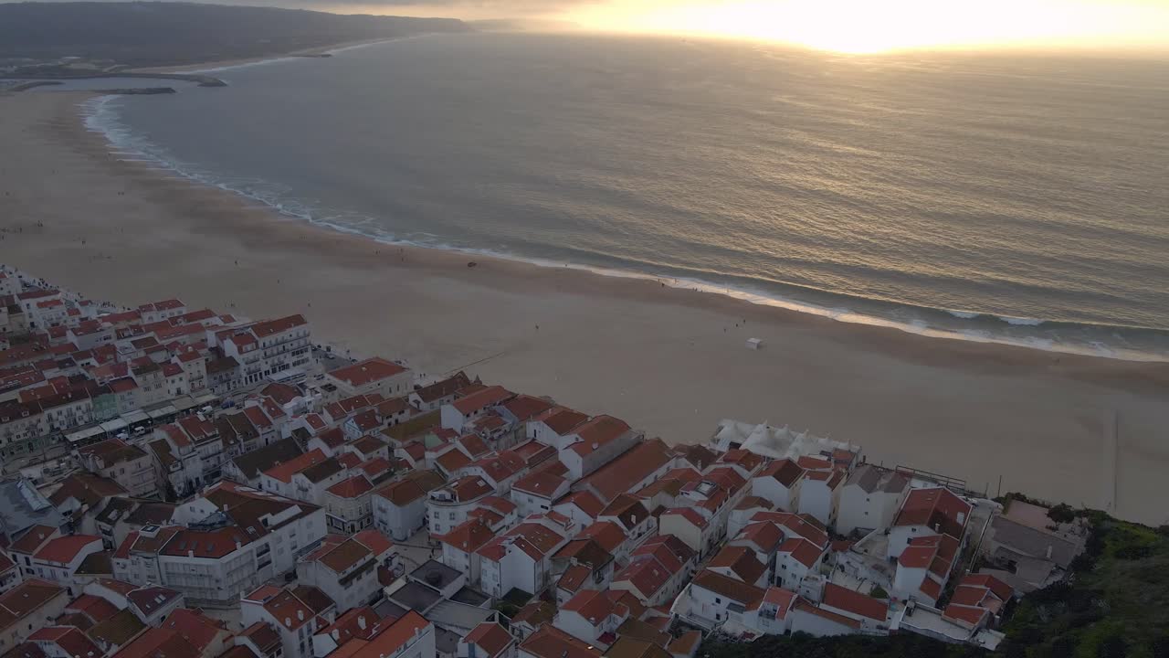 포르투갈 해안에 있는 나자레 마을의 지역 드론 영상이 일몰 골든 아워 4k 동안 촬영되었습니다.