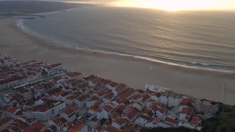 imágenes de drones de la ciudad de nazare en la costa de portugal filmadas durante la hora dorada del atardecer 4k