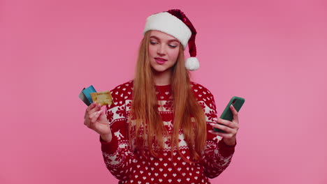 Frau-Im-Weihnachtspullover-Nutzt-Mobiltelefon-Und-Plastikkreditkarte,-Gewinnt,-Kalebiert,-Wow