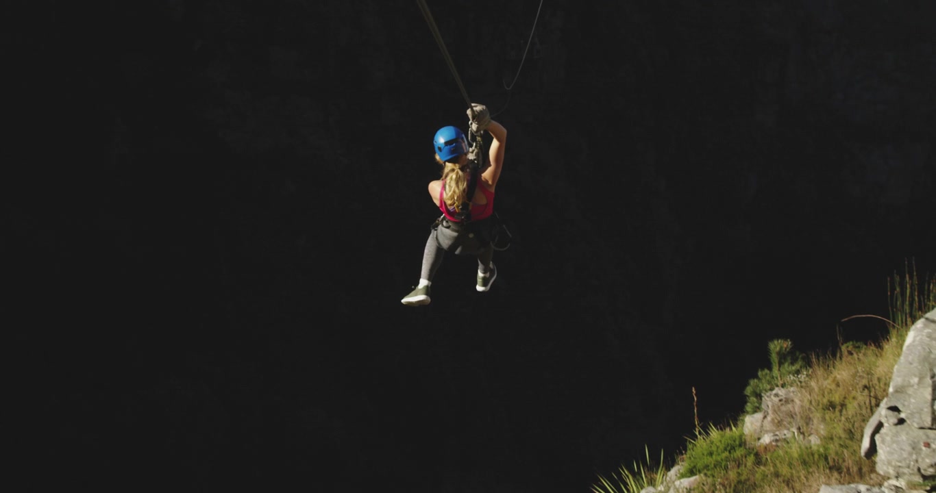 Giovane donna caucasica che fa zip-line