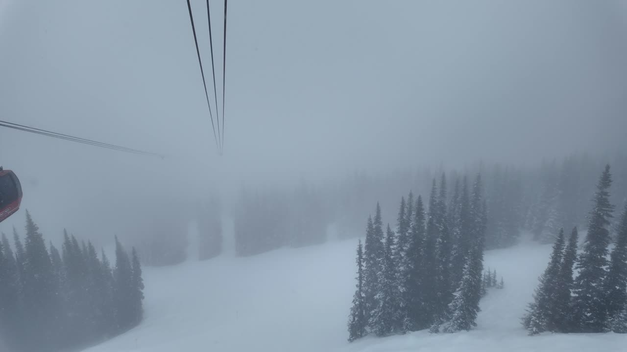 Kraftig snøfall og tåke i Whistlers fjellområde; luftperspektiv fra PEAK 2 PEAK gondolen som forbinder Whistler Blackcomb-fjellet med Whistler Mountain skianlegg.
