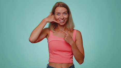 Cheerful-one-woman-in-crop-top-looking-at-camera-doing-phone-gesture-like-says-hey-you-call-me-back