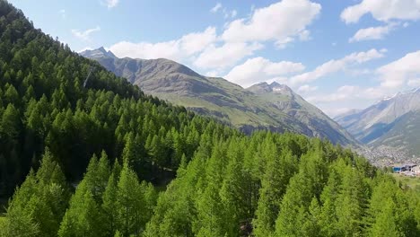 Flight-over-a-forest-in-the-beautiful-Swiss-Alps-mountains-with-the-Zermatt-town-in-the-background