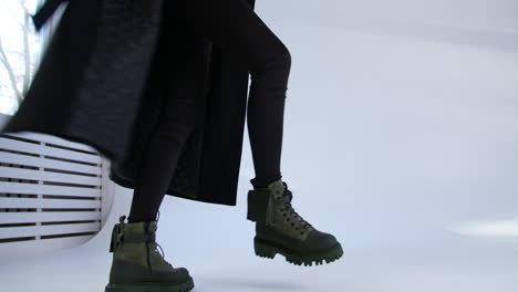 woman in black coat and olive green boots