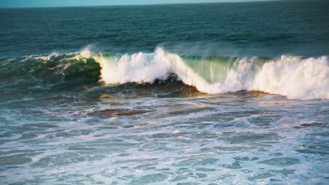 white sea waves rolling seashore on sunny day. slow motion ocean swelling break