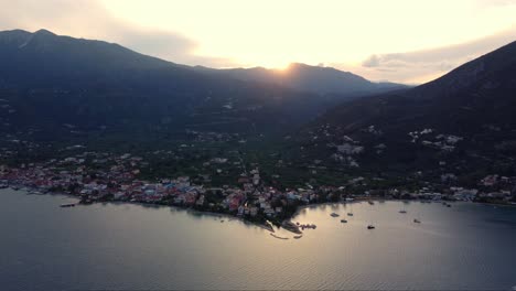 aerial of nydri town community on the eastern coast of the island of lefkada at sunset surrounded by vast green area with trees and lush vegetation