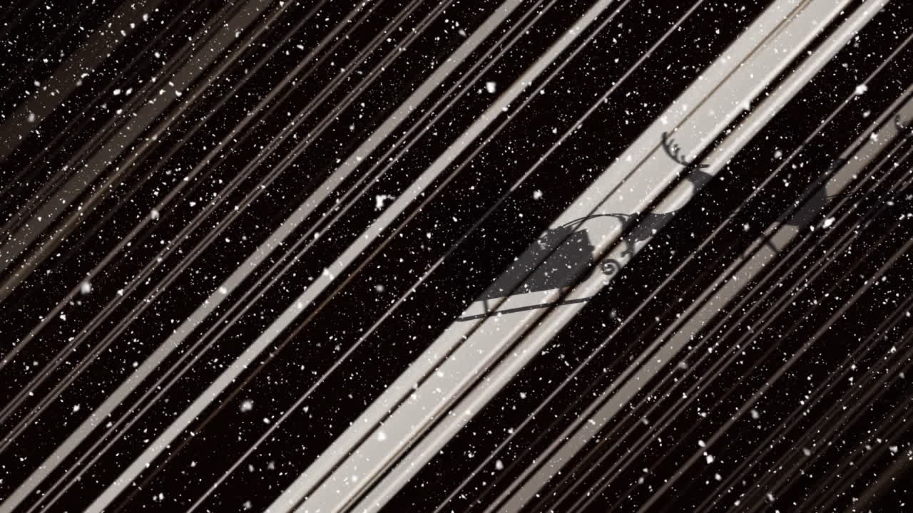 Animation af sne der falder over julemanden i kane med rensdyr, der bevæger sig på sort baggrund