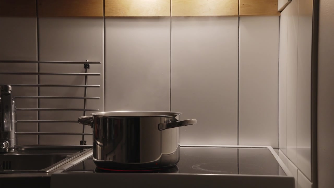 Stainless Steel Pot Boiling on Electric Stove in Kitchen