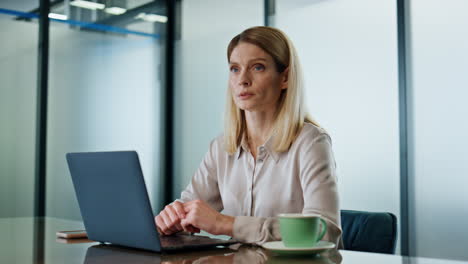 focused lady sipping coffee modern cabinet closeup. person taking office break