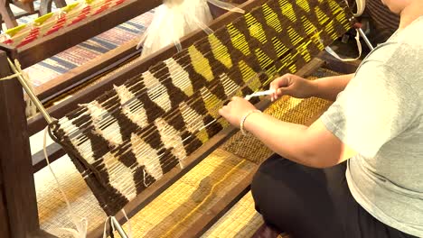 artisan weaving intricate patterns on silk fabric