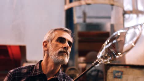 glassblower shaping a molten glass