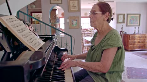 old woman playing a grand piano at her home