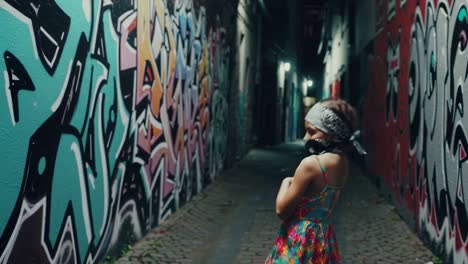 child in graffiti alley at night