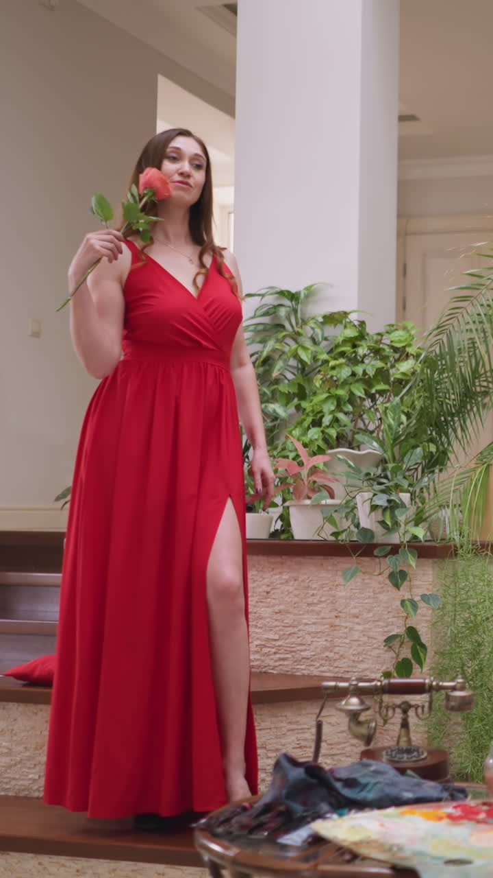 художник создает шедевр живописи женщины. модельная поза и нежная роза в руке дают вдохновение для творческих усилий художника.