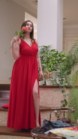 artista produz uma pintura de obra-prima mulher. pose de modelo e rosa delicada na mão fornecem inspiração para os esforços criativos do artista. ambiente de arte