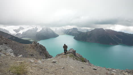 Hombre-En-La-Cima-De-Una-Colina-Con-Lago-Turquesa-En-El-Parque-Provincial-Garibaldi-En-Columbia-Británica,-Canadá