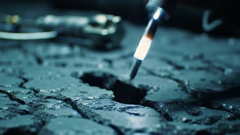 detailed close-up of a tool interacting with a textured surface, revealing cracks and gaps, highlighting the intricacies of material interaction and precision work