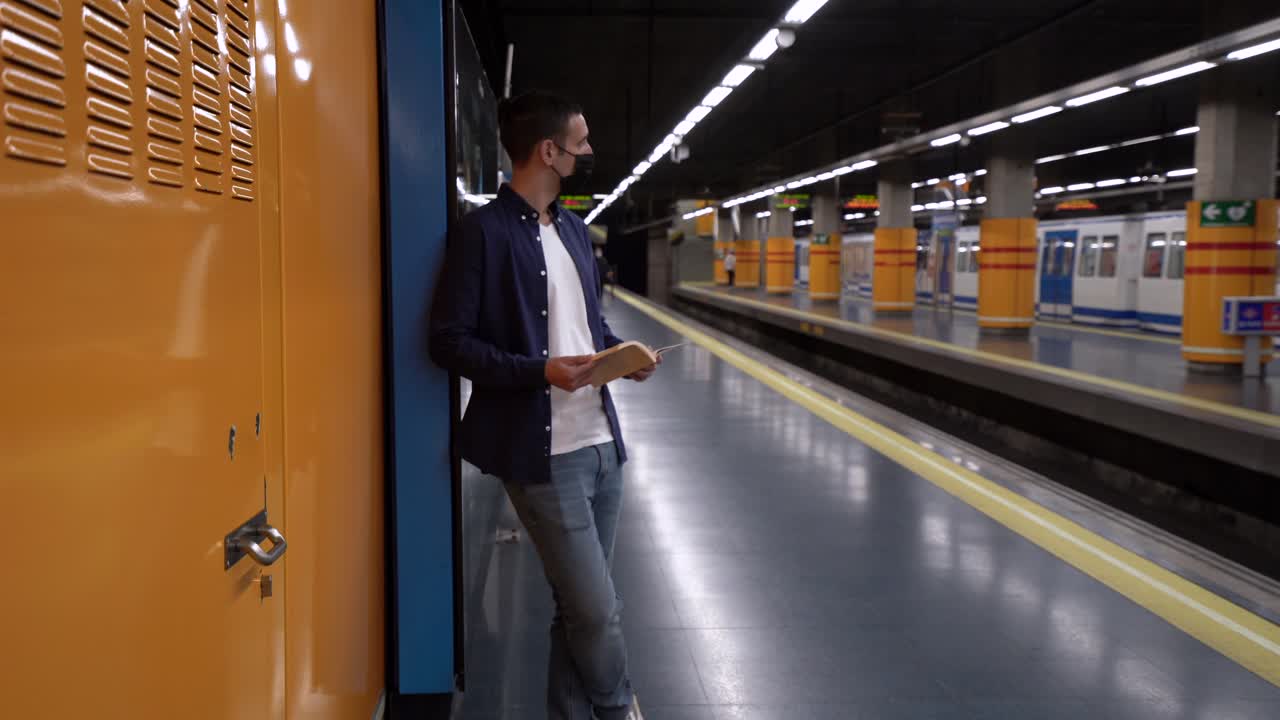 Studente anonimo che legge un quaderno di esercizi sulla piattaforma della metropolitana