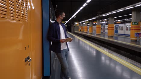 estudiante anónimo leyendo libro de trabajo en la plataforma subterránea