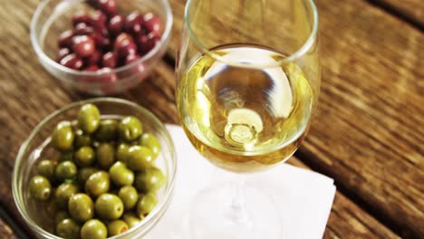 wine served with green and red olives on wooden table