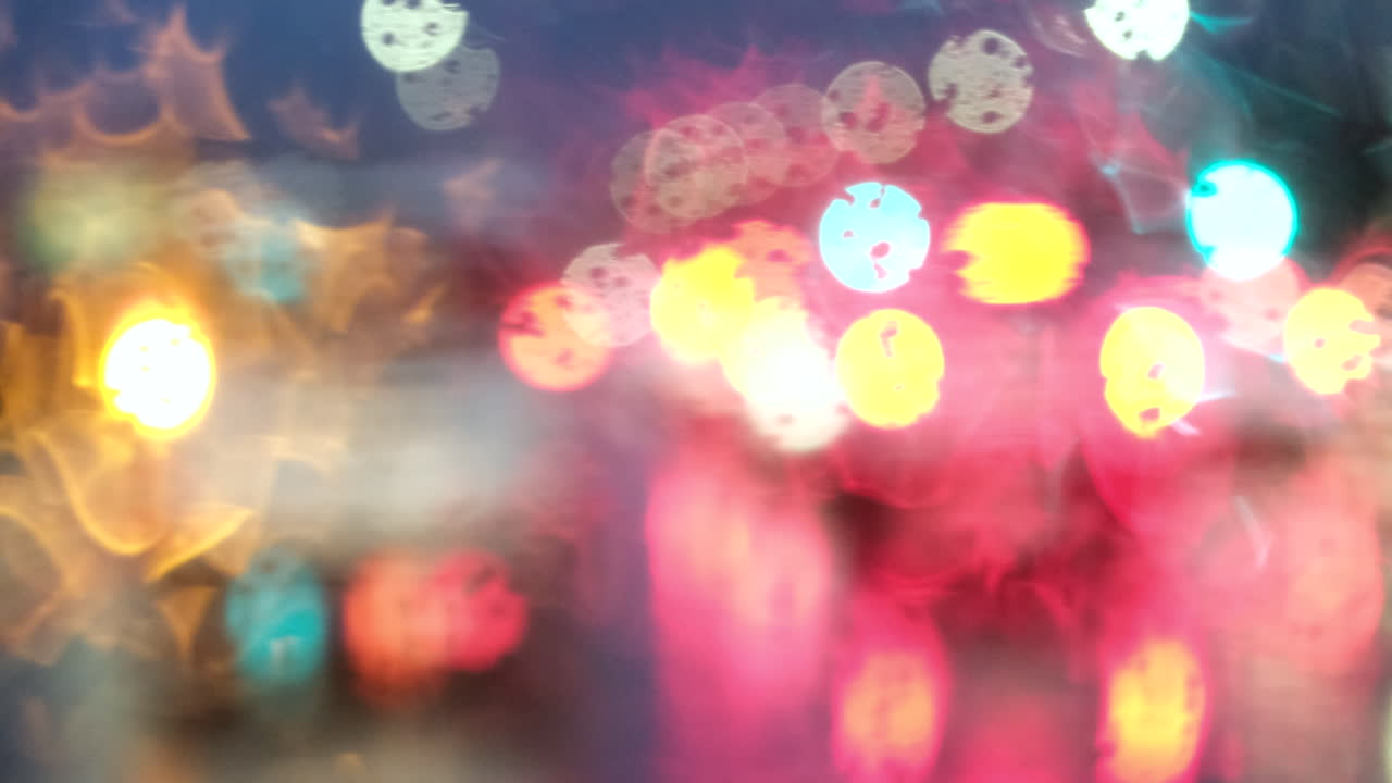 Driving at dawn on wet rainy road with car lights reflecting, POV abstract view