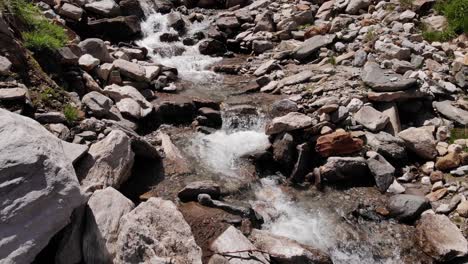 rapids flowing over large rocks of valleys near stausee wasserfallboden in kaprun, austria