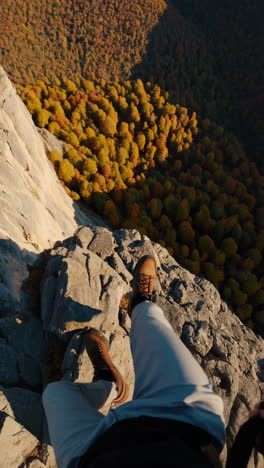 first-person view looking down from a cliff edge in autumn