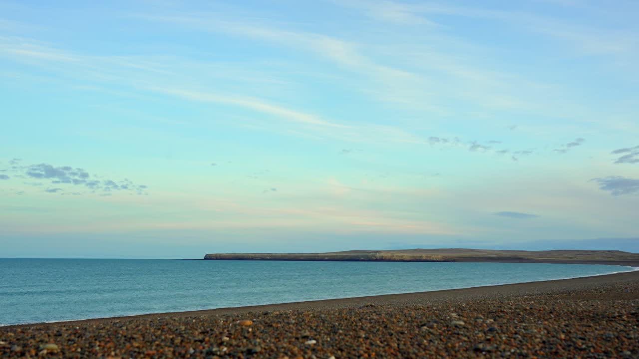 Calm Atlantic coast in Santa Cruz, with wide pebbled beach at sunset. Santa Cruz, Argentina. Timelapse