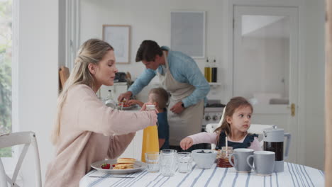 Familie-Frühstückt-Zusammen-Und-Isst-Pfannkuchen.-Mutter-Und-Vater-Bereiten-Am-Wochenendmorgen-Hausgemachte-Mahlzeiten-Für-Kinder-Zu.-4k